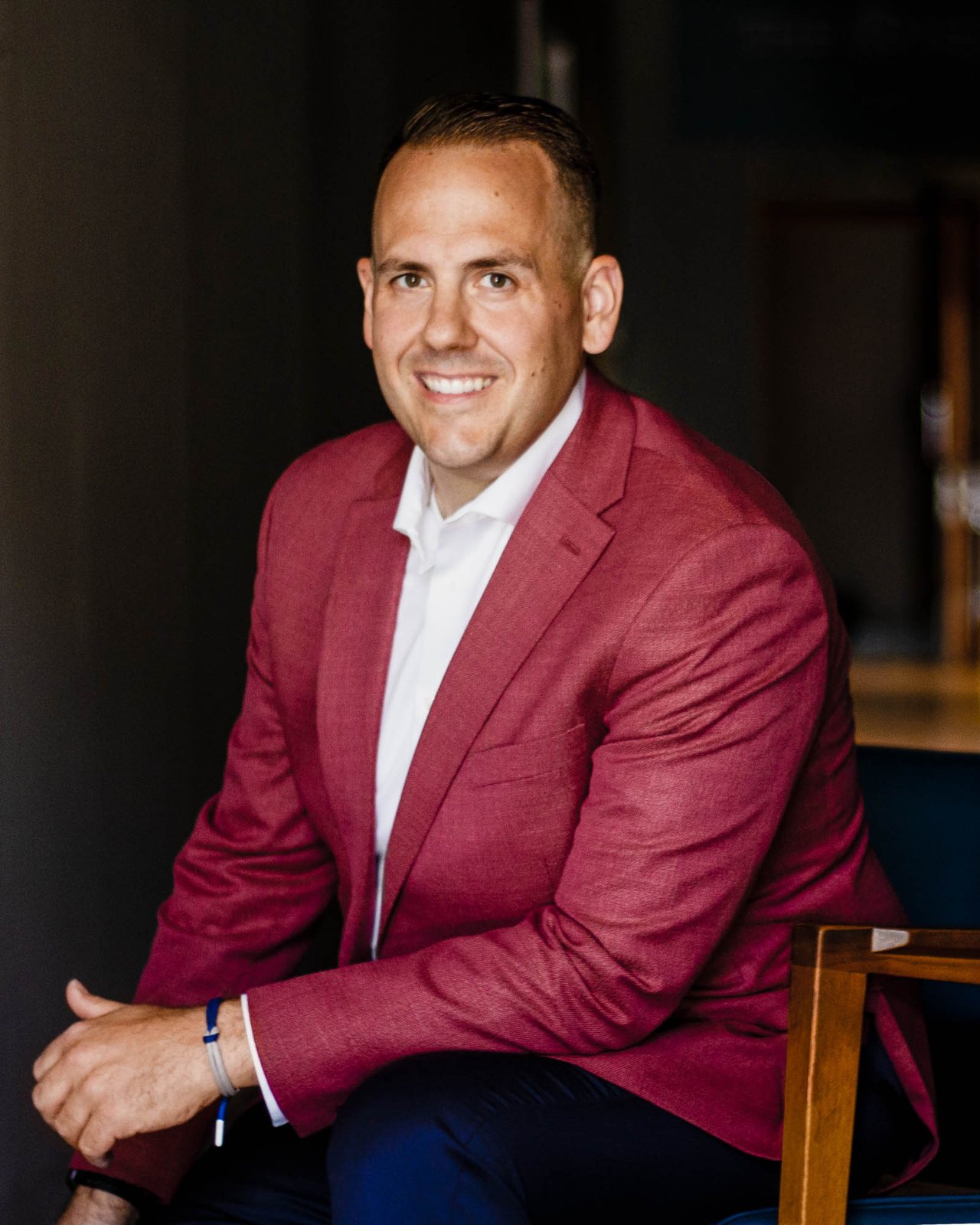 Jake Hamann — Seated, red blazer